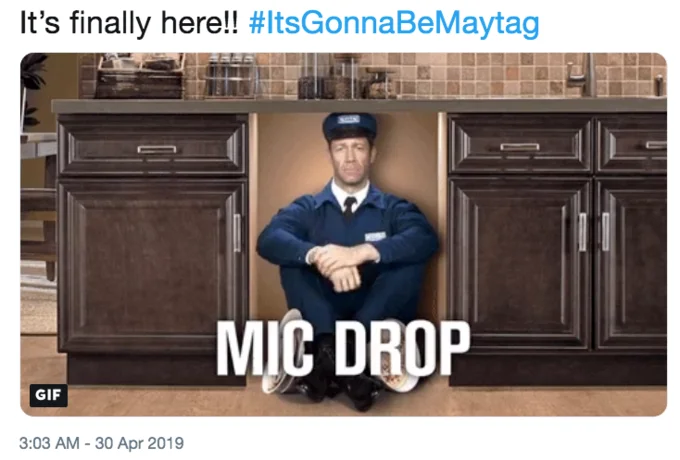 "It's Gonna Be May" — Tweet screenshot with Maytag repairman under kitchen sink and 'MIC DROP' text, hashtag ItsGonnaBeMaytag