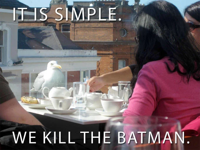 It's Simple, We Kill The Batman — Seagull on outdoor cafe table with caption 'It is simple, we kill the Batman'