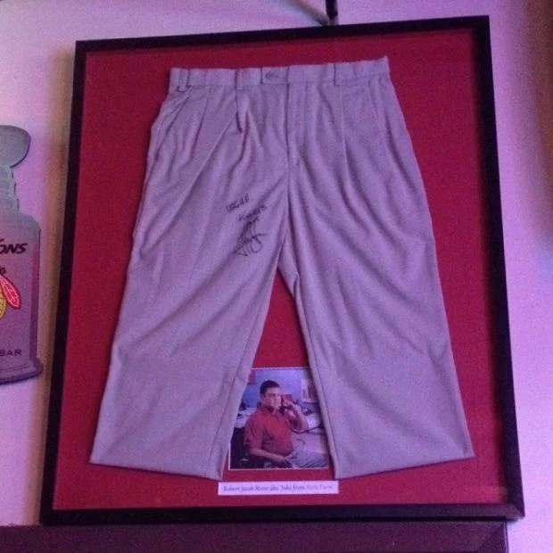 Jake Stone, the actor behind Jake from State Farm, sitting on a stool in a sports bar