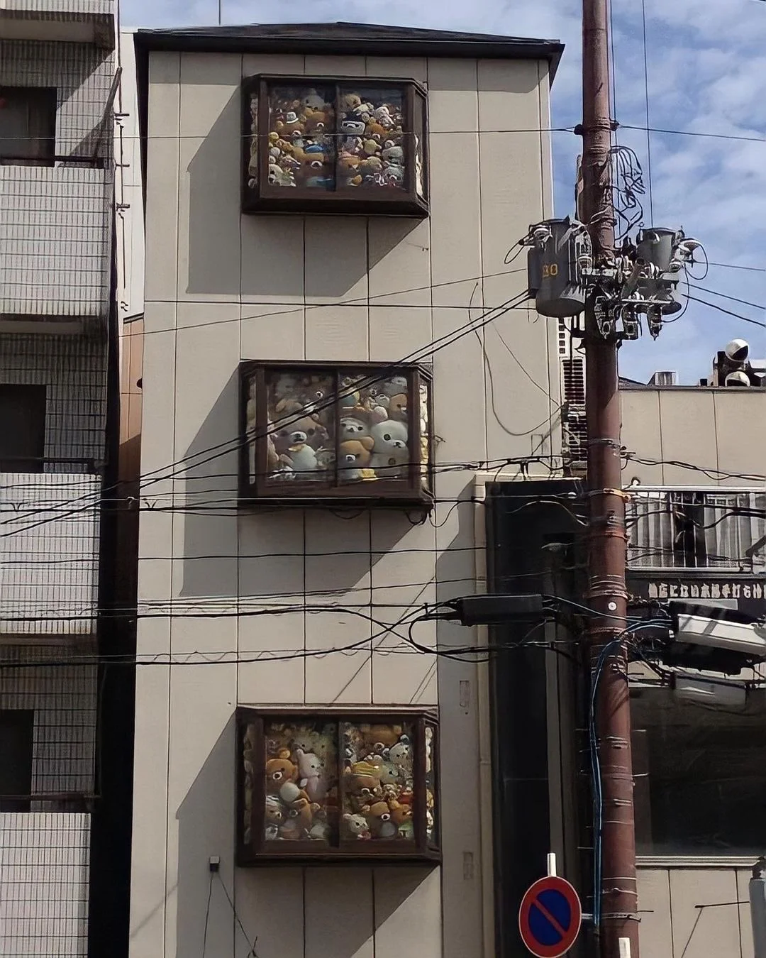 Japanese building with windows filled with stuffed animals