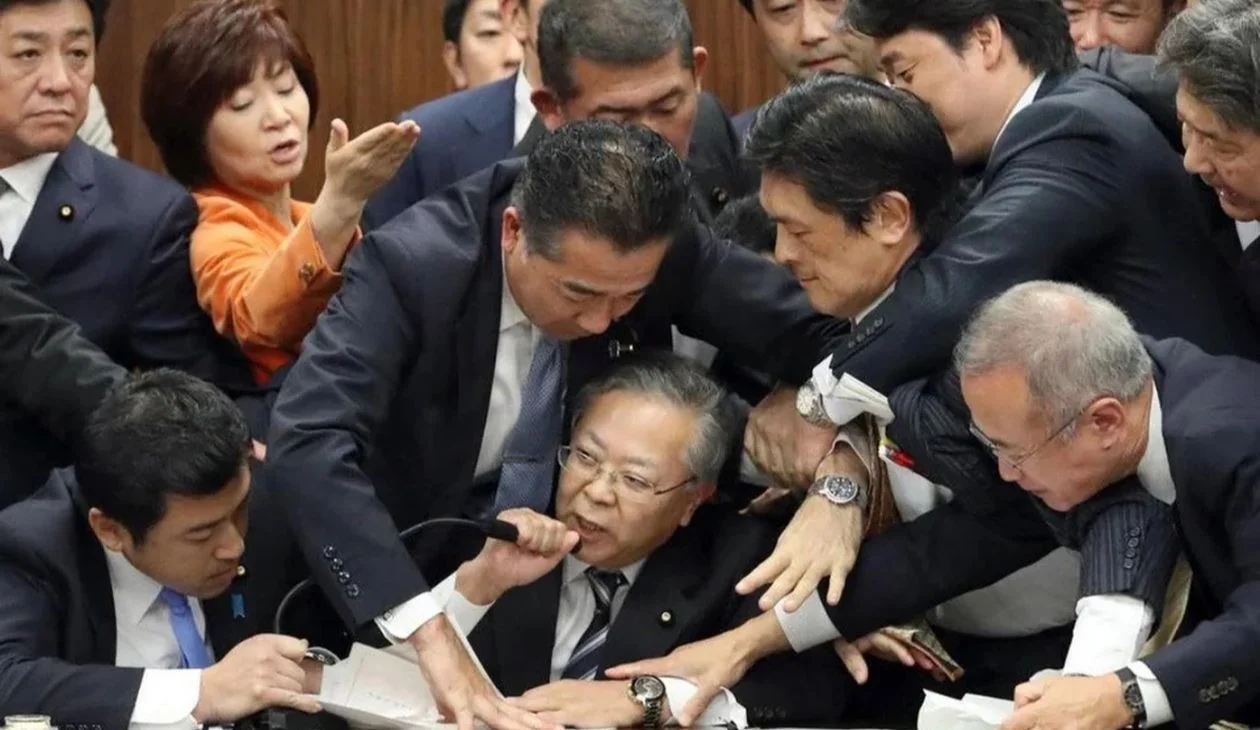 Japanese Parliament Trying To Stop Shinichi Yokoyama — Japanese parliament members scrum around Shinichi Yokoyama as he holds a microphone to his mouth