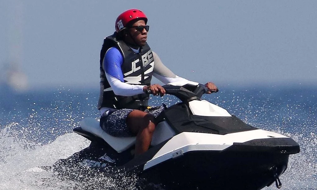 Jay-Z On a Jet-ski — Jay-Z in red helmet and life vest riding a jet ski on the ocean