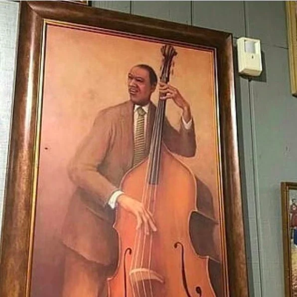 Jazz Music Stops — Photograph of the framed jazz bassist painting hanging on a wall