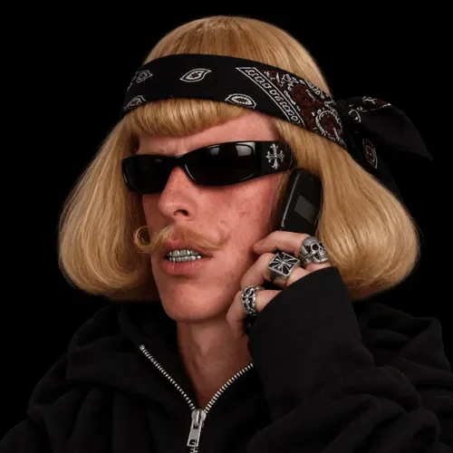 Jean Phil wearing bandana, sunglasses and grillz while talking on a flip phone