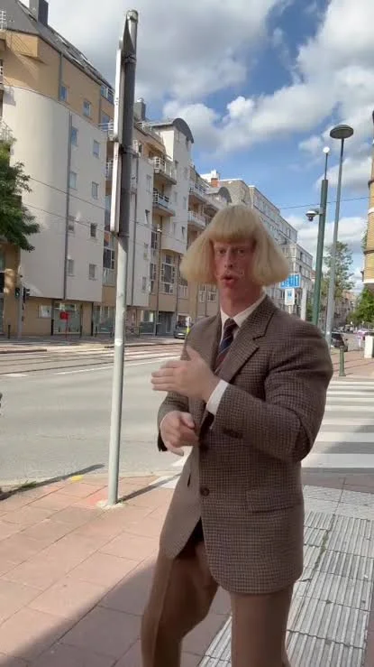 Jean Phil on a city street wearing tweed suit, from the She feels safe with the man video