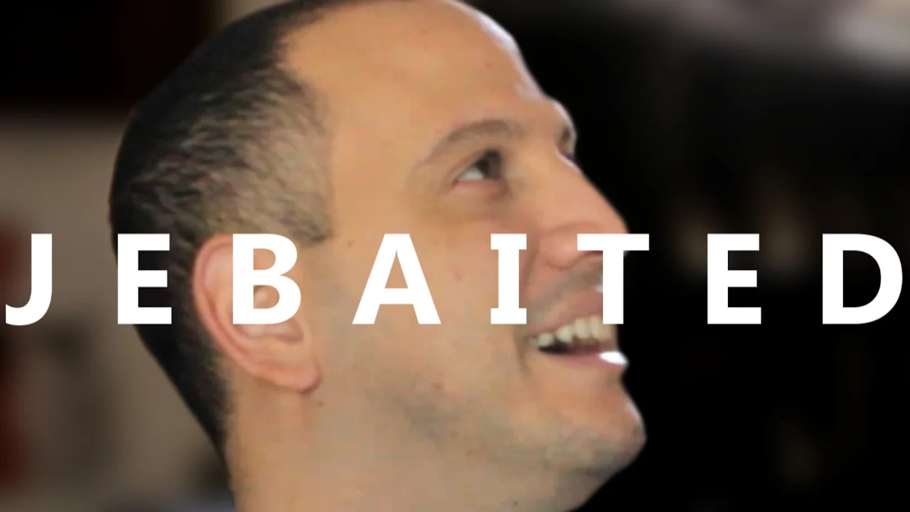 Alex Jebailey smiling upward with the word JEBAITED overlaid in bold white text