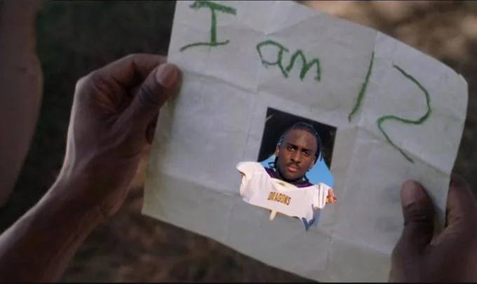 Jeremiah Johnson The 12 Year Old Football Player — Hands holding paper reading 'I am 12' with cutout photo of Jeremiah Johnson in Dragons jersey