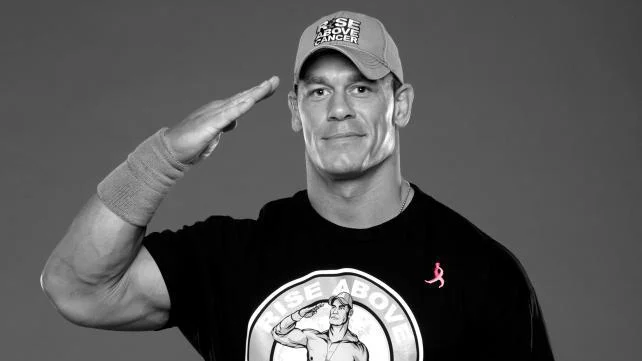 John Cena Prank Call — A professional grayscale portrait of John Cena in casual attire making a friendly saluting gesture.