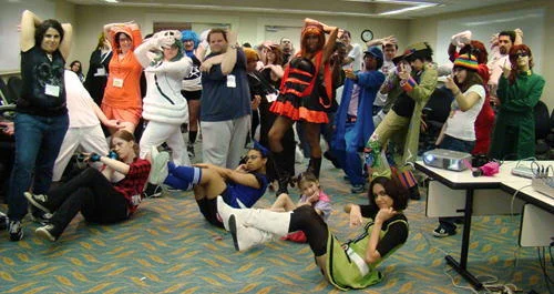 Jojos Pose — Large group of cosplayers at an American anime convention strike exaggerated angular JoJo Dachi poses in a conference room.