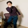 Jojos Pose — A person in a dark purple top striking a JoJo-style dramatic lean with one arm extended in an indoor setting.
