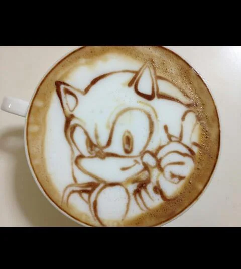 Latte art depicting Sonic the Hedgehog giving a peace sign in a coffee cup.