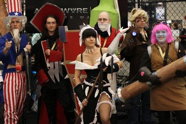 League of Legends cosplayers at Riot Games booth with Dominion sign