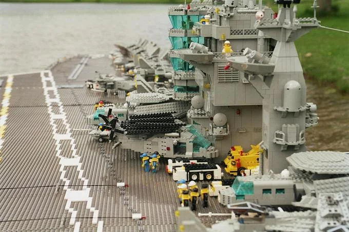 Close-up of LEGO aircraft carrier deck with LEGO jets and crew