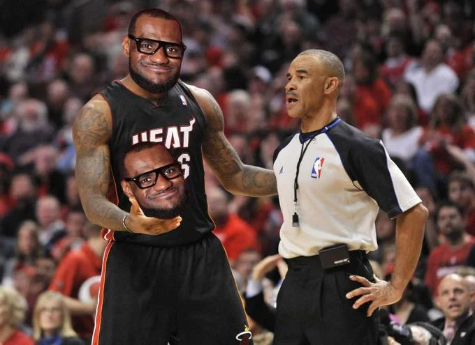 LeBron James holding a cutout of the Lelbron face during an NBA game