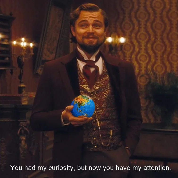 Leonardo DiCaprio — DiCaprio as Calvin Candie holding a globe with the caption 'You had my curiosity, but now you have my attention'
