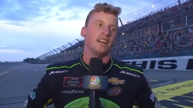 Let's Go Brandon — Photograph of NASCAR driver Brandon Brown speaking at microphone during post-race interview at race track.