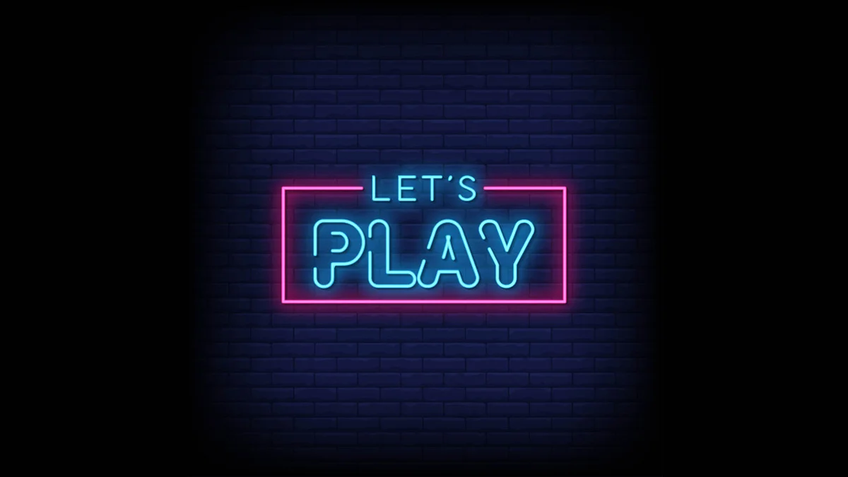 Neon 'Let's Play' sign in blue and pink on a dark brick wall