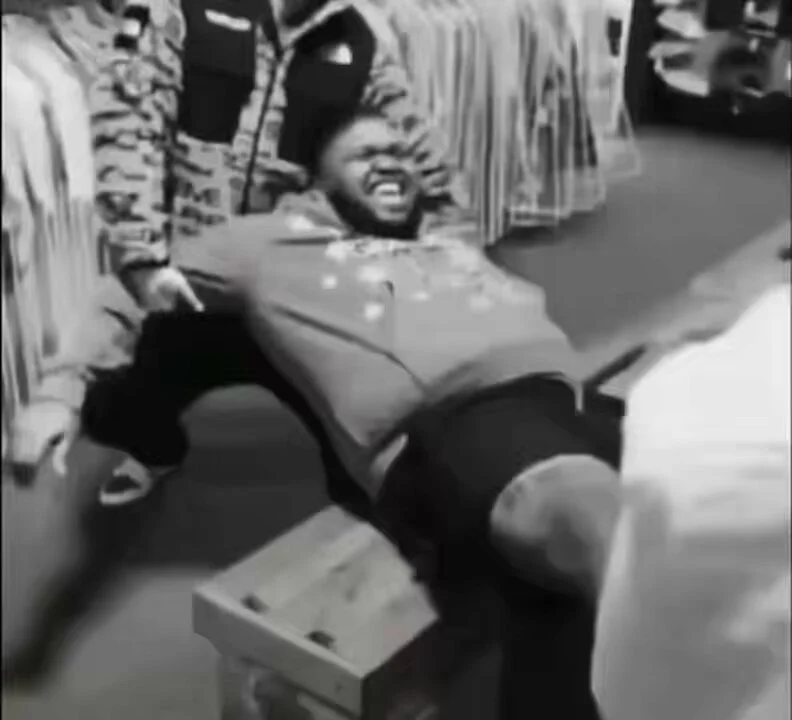 Lindsay Clancy Trial — Grayscale image of a person mid-fall in a clothing store, grimacing as they land on a wooden crate.