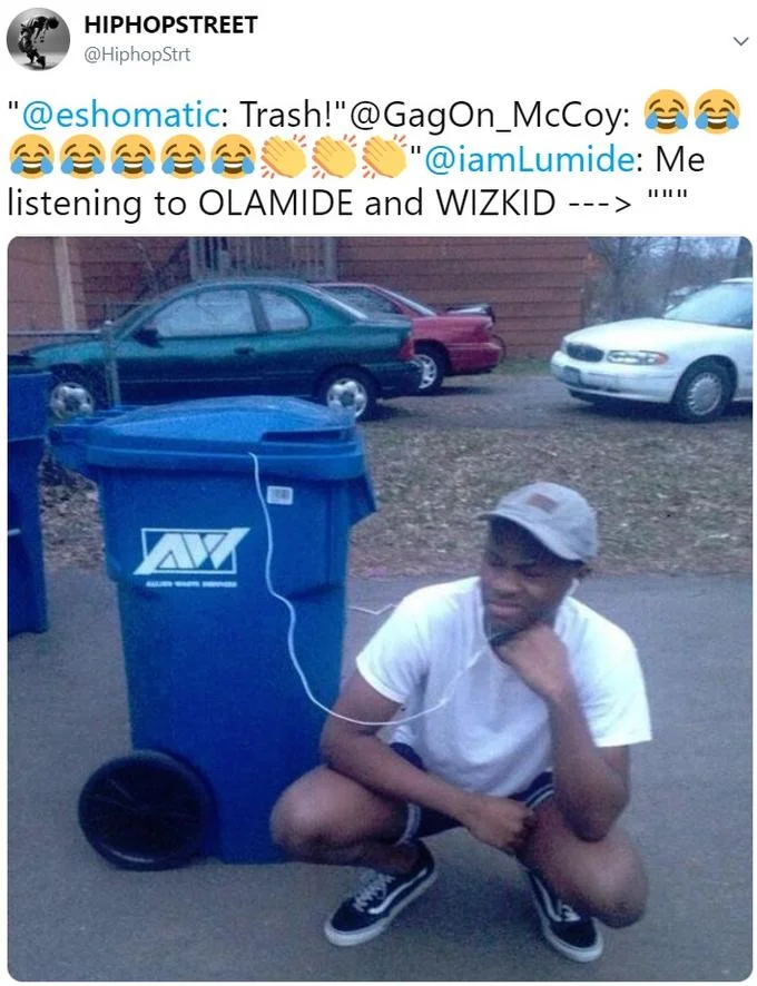 Listening to Trash — Twitter post from HipHopStreet showing man crouched beside blue trash bin with earbuds in it, joking about listening to Olamide and Wizkid