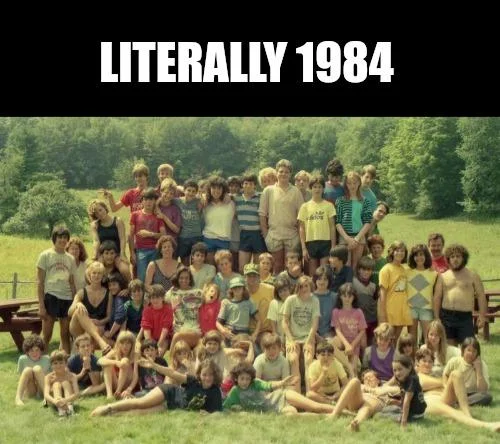 Large outdoor group photo of people with 'LITERALLY 1984' text overlay in white on black background.