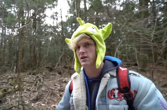 Logan Paul in green alien hat filming inside Aokigahara forest