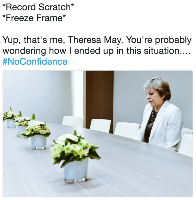 Lonely Theresa May — Record scratch freeze frame meme with Theresa May alone at conference table and #NoConfidence hashtag.