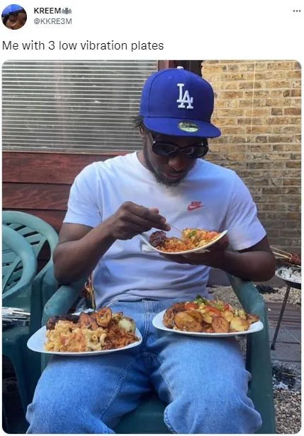Tweet showing a man in an LA Dodgers cap with three plates of food captioned 'Me with 3 low vibration plates'.