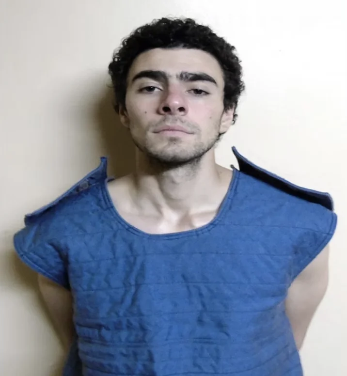 Luigi Mangione Is Not The Shooter Conspiracy Theory — Luigi Mangione in blue jail clothing after arrest
