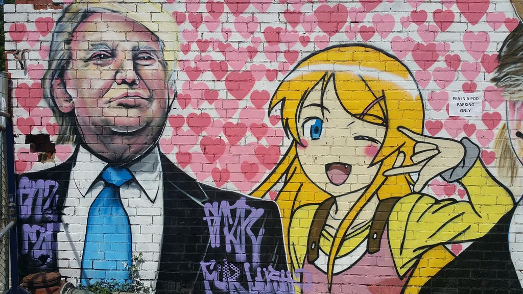 Lushsux — Mural of Donald Trump next to a winking blonde anime girl on a heart-covered brick wall