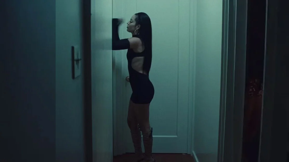 Maddy Banging On Door — Maddy Perez in a black cutout dress banging on a white door in a dim teal-lit hallway in Euphoria
