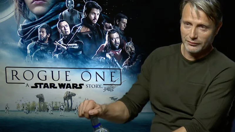 Mads Mikkelsen Opening Vodka During Interview — Actor Mads Mikkelsen in an official interview for Rogue One: A Star Wars Story, in gray-green shirt with the