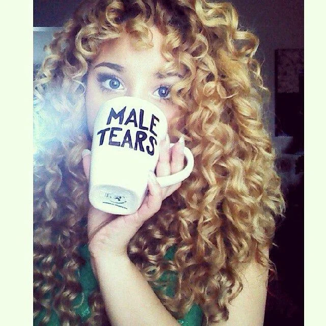Curly blonde woman drinking from hand-painted Male Tears mug