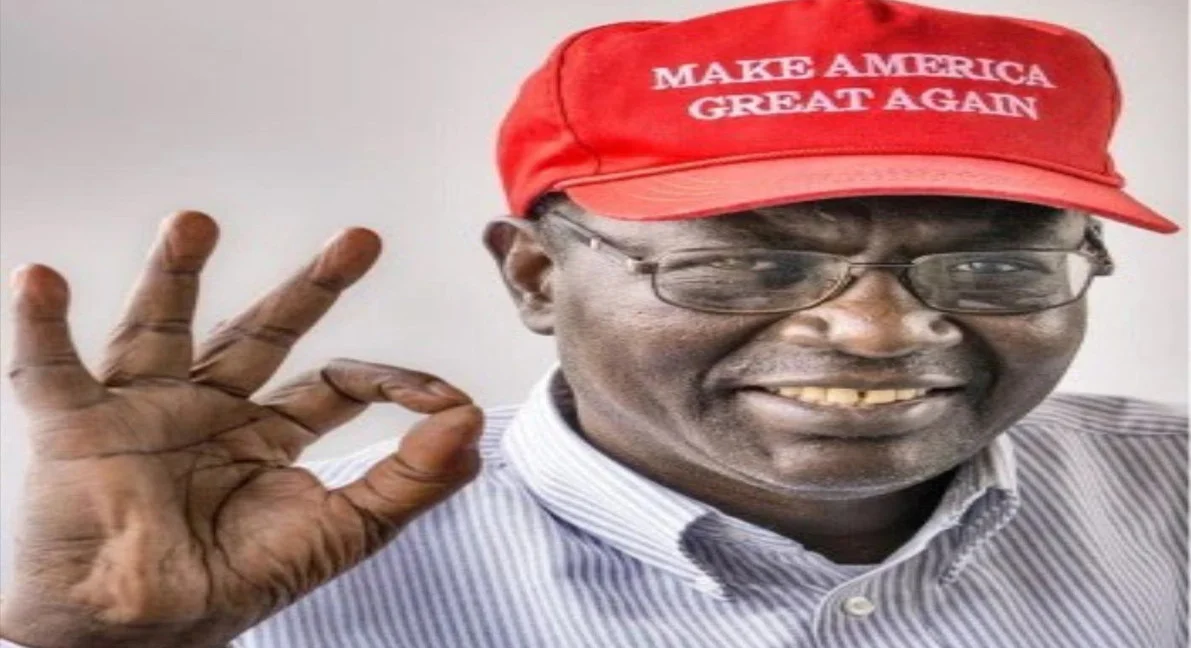 Malik Obama smiling in a red MAGA cap making an OK hand sign