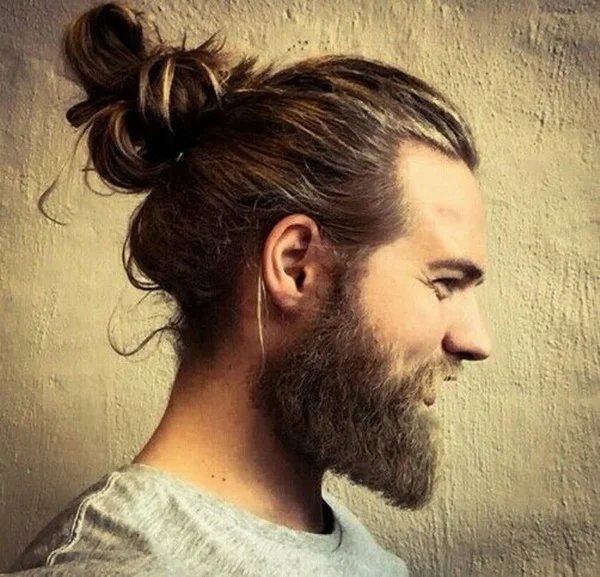 Man Bun — Bearded man in profile wearing a high, loose man-bun hairstyle.