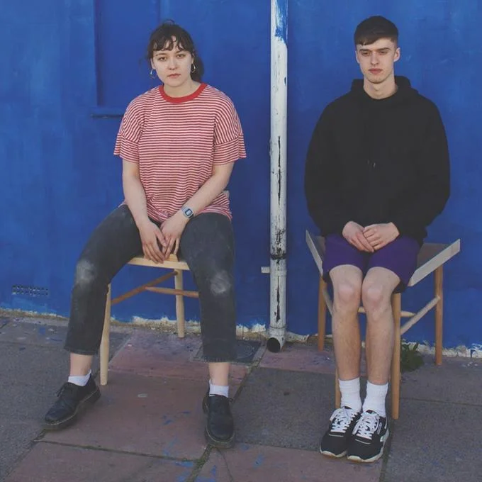 Man and woman on contrasting seats from an anti-manspreading design project
