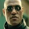 Matrix Morpheus — Professional headshot of Morpheus wearing distinctive dark round sunglasses against vibrant green Matrix-themed background.
