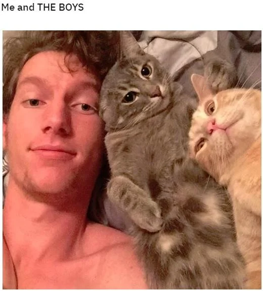 Photograph of a person posing with two cats, captioned as literal interpretation of Me and the Boys meme.