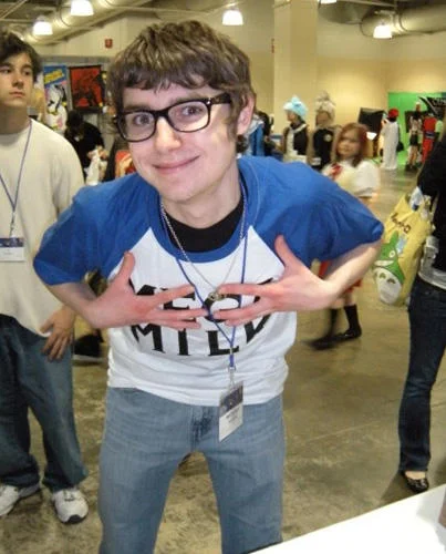 Convention fan wearing Mega Milk shirt posing with hands under chest
