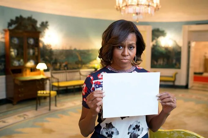 Michelle Obama holding a blank sign template in the White House