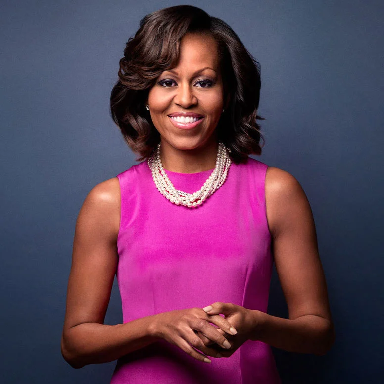 Michelle Obama smiling in a pink dress and pearl necklace, official portrait