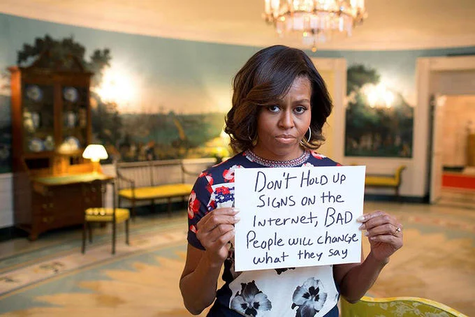 Michelle Obama holding a handwritten warning sign about internet meme edits