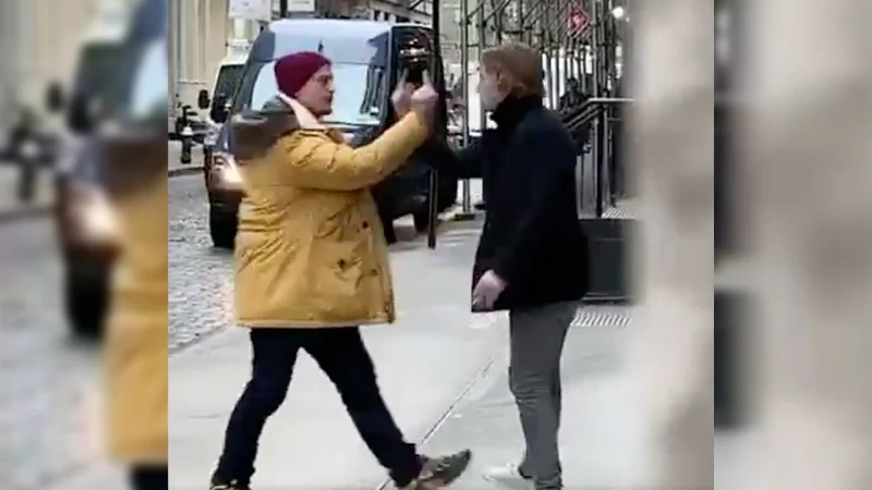 Middle Finger Duel — Two people on a city sidewalk holding middle fingers up in each other's faces