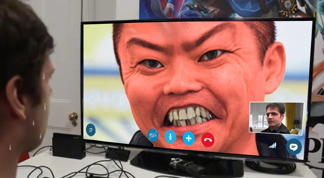 MISTAH MERRIKU — Nervous sweating man on a video call with an angry close-up of Junichi Masuda shown on a TV screen