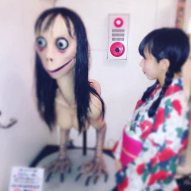 Girl in kimono posing next to Momo Mother Bird sculpture at Japanese exhibit