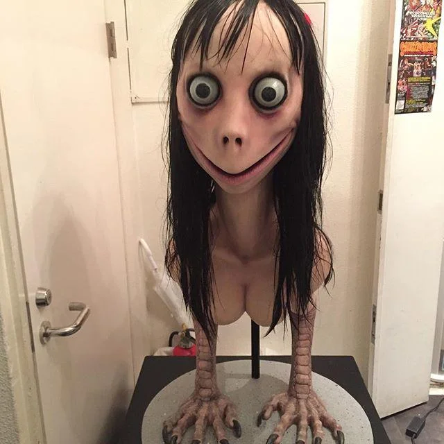 Full-length photograph of Momo sculpture on pedestal showing bird-like legs and characteristic features.