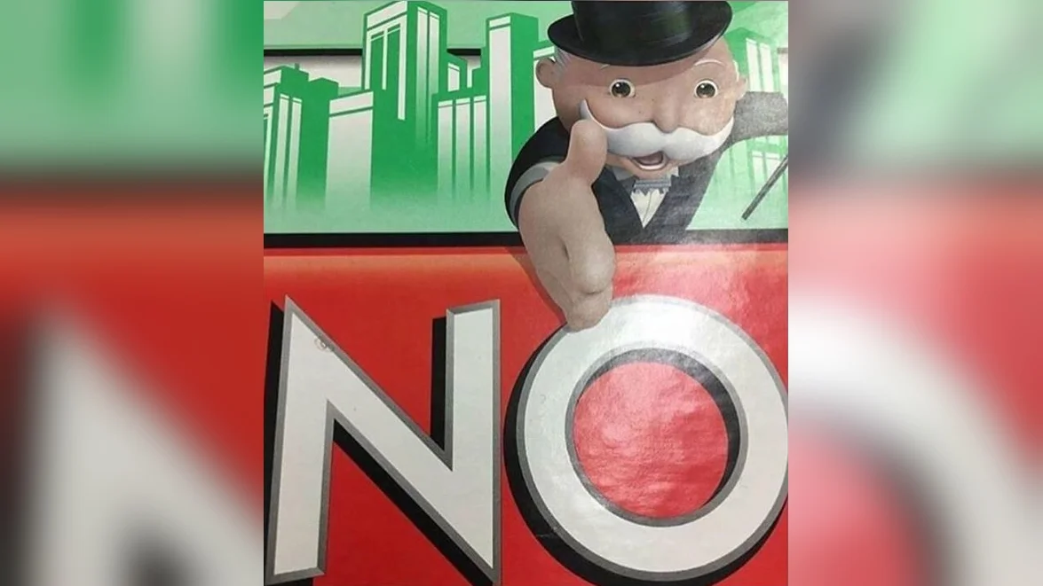 Monopoly Man's "NO" — Monopoly Man mascot pointing at a large red NO sign on a Monopoly board