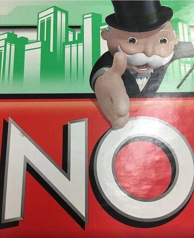 Monopoly Man's "NO" — Rich Uncle Pennybags leaning over Monopoly board pointing at large red NO sign