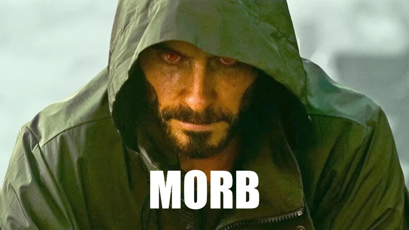 Cinematic still of Jared Leto as Morbius with green hood, shadow, and glowing red eyes.