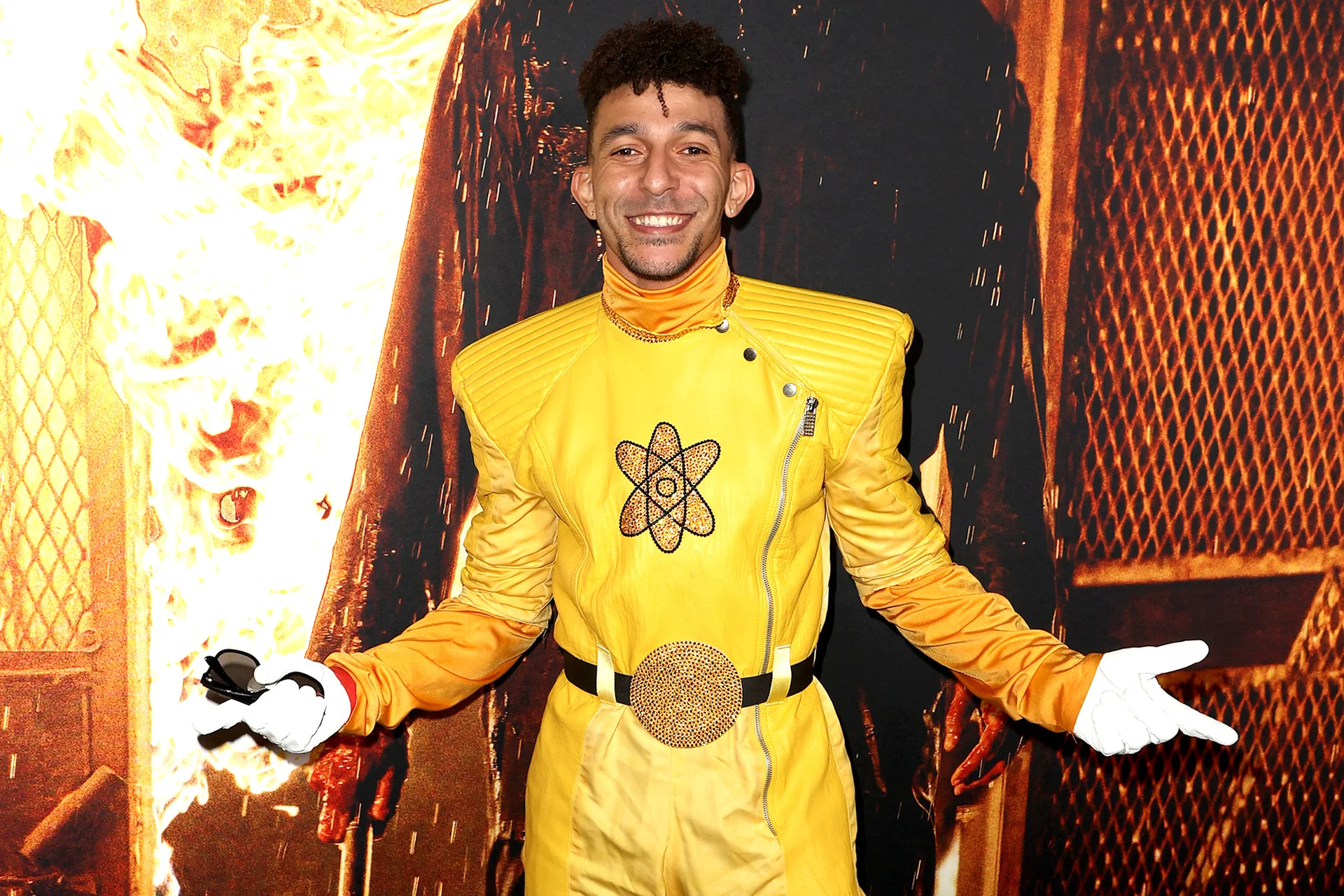 Man in yellow atom-emblem costume posing at a Mortal Kombat 11 promotional event