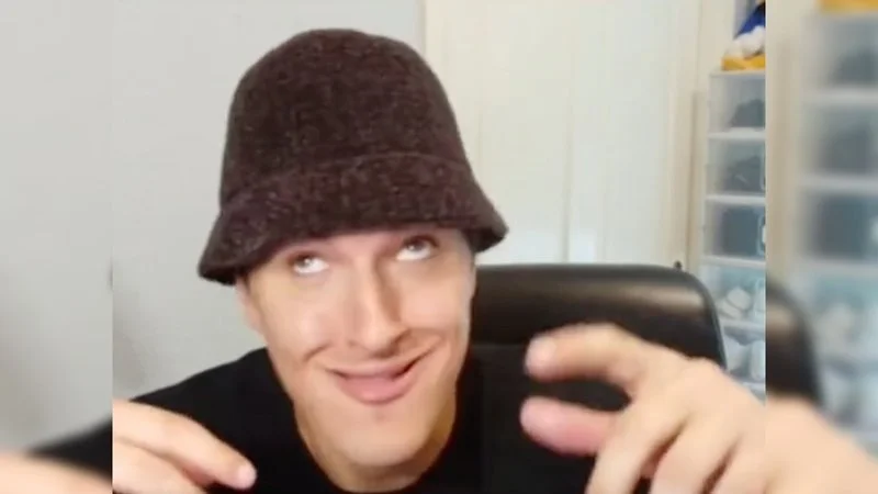 My Brother Bilo — Young man in brown bucket hat making wide-eyed goofy smirk at camera in webcam recording.